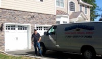 a man standing in front of a house with a van